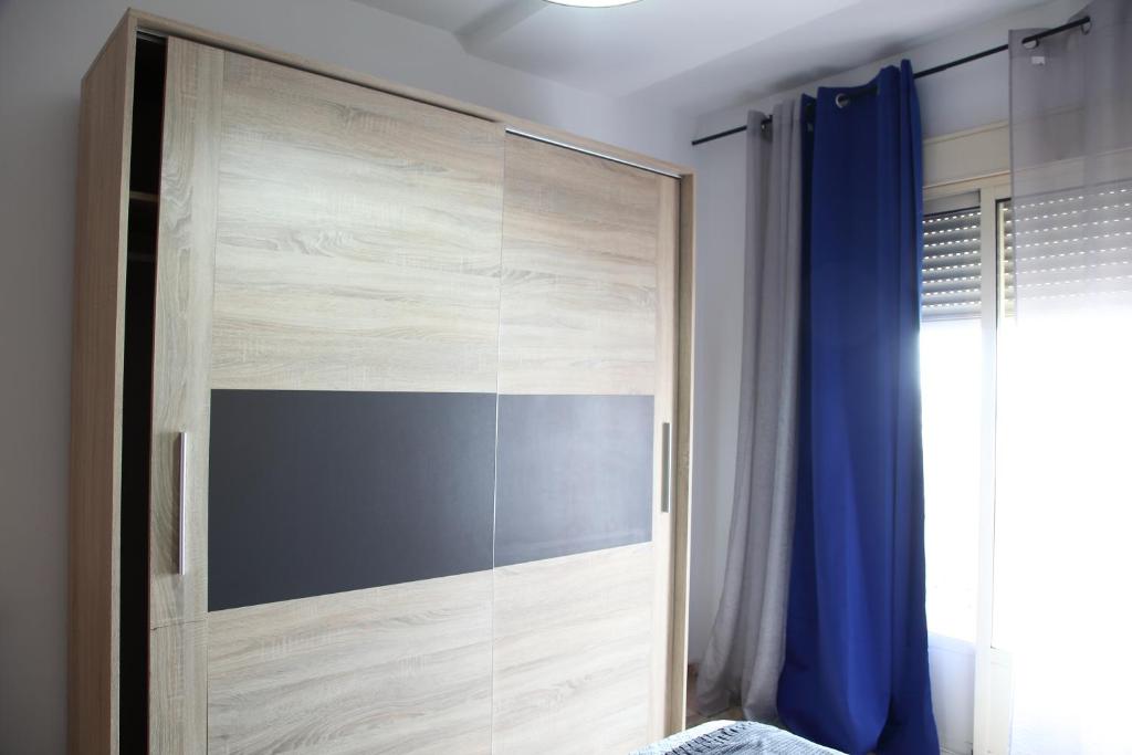 a sliding glass shower door with a blue curtain at Apartamento Vino Tinto in Valdepeñas