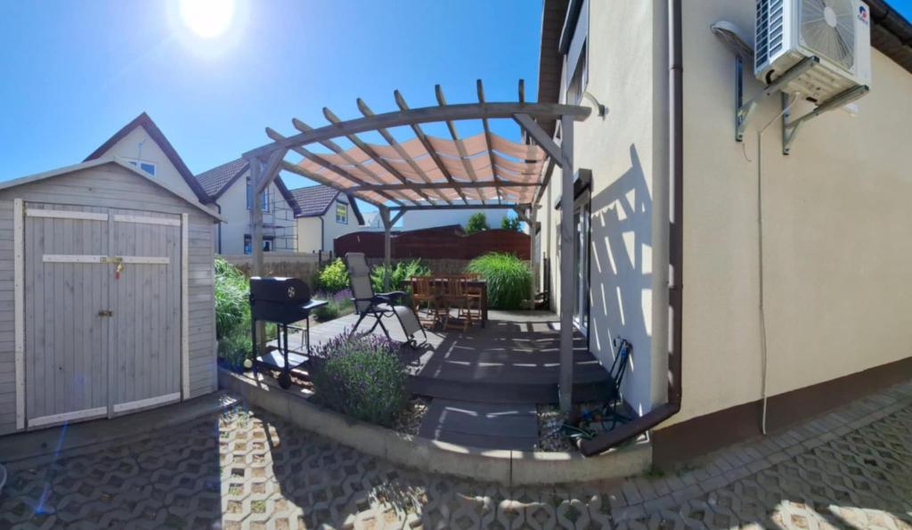 a patio with a wooden pergola next to a building at Zakątek Rumiankowa Rewal in Rewal