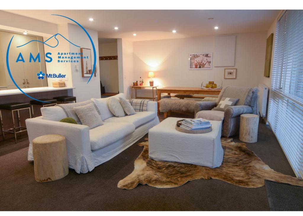 a living room with two couches and a table at Twin Towers 102a AMS Mt Buller in Mount Buller