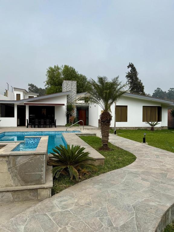 a villa with a swimming pool and a house at Casa los Cipreses del Sol in Cieneguilla