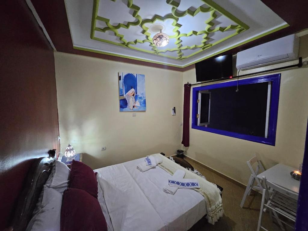 a bedroom with a bed and a flat screen tv at Bluemoon house in Chefchaouen