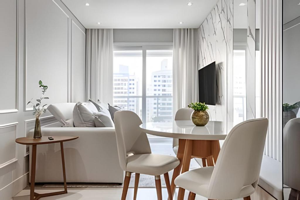 弗洛里亚诺波利斯Elegante apto Região Central Florianópolis/SC的一间带桌子和白色椅子的餐厅