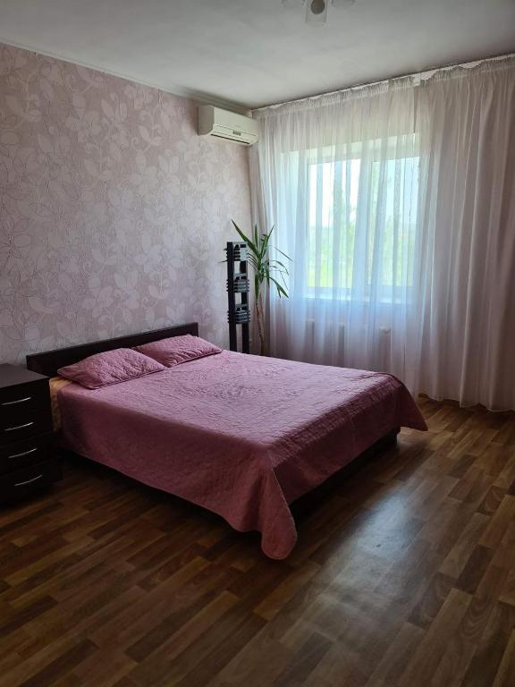 a bedroom with a large bed and a window at Rohovska appartment in Odesa