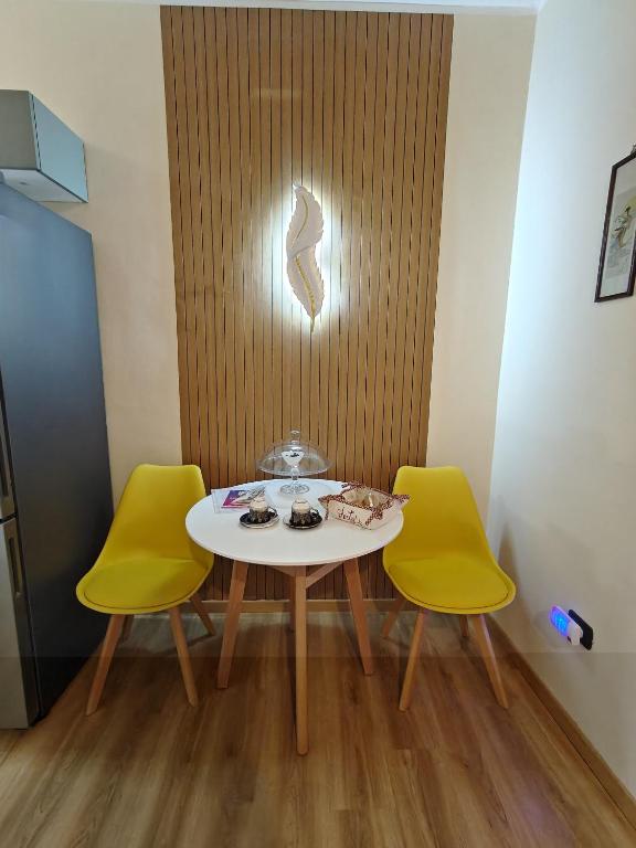 a table and two yellow chairs in a room at Arty's Apartment in Trieste