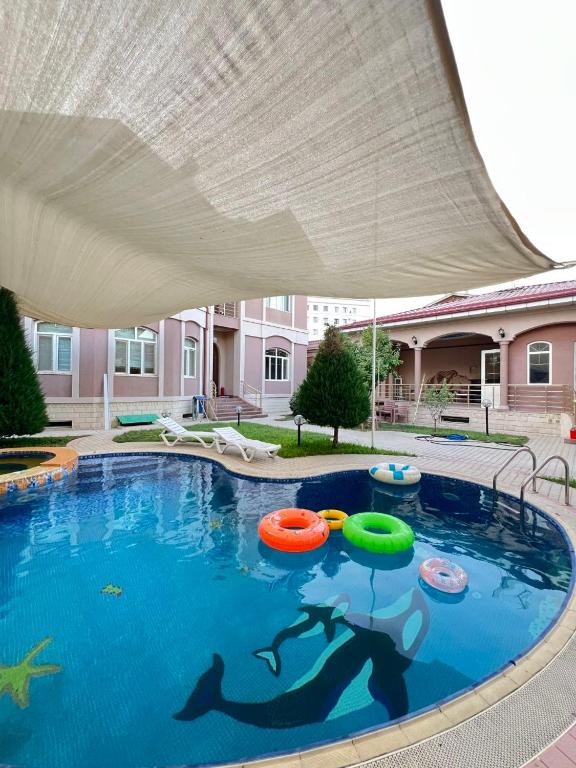 a swimming pool with three inflatable trampols in it at MIMFRI PREMIUM guest house, hotel in Tashkent