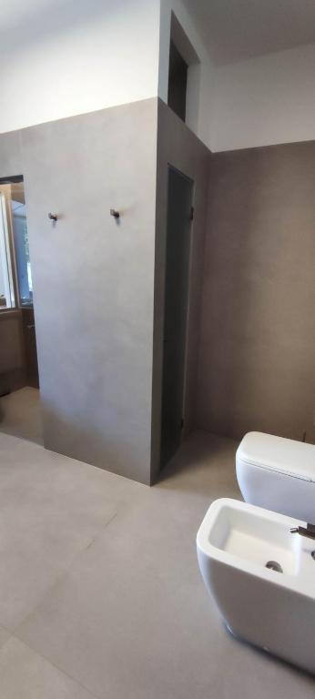 a bathroom with a white toilet and a sink at Villeriunite - Villa Dalia in Baia Verde