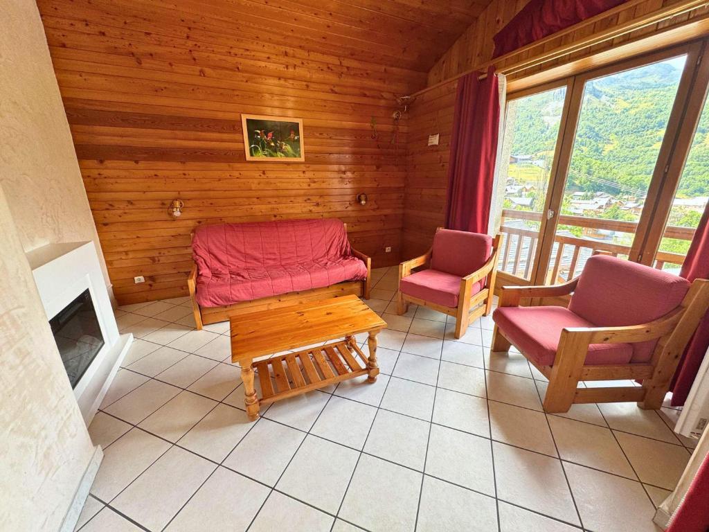 un salon avec deux chaises et une cheminée dans l'établissement Appartement Confortable 85m² pour 6 Pers. avec Terrasse, à 300m des Pistes à St Martin de Belleville - FR-1-452-382, à Saint-Martin-de-Belleville