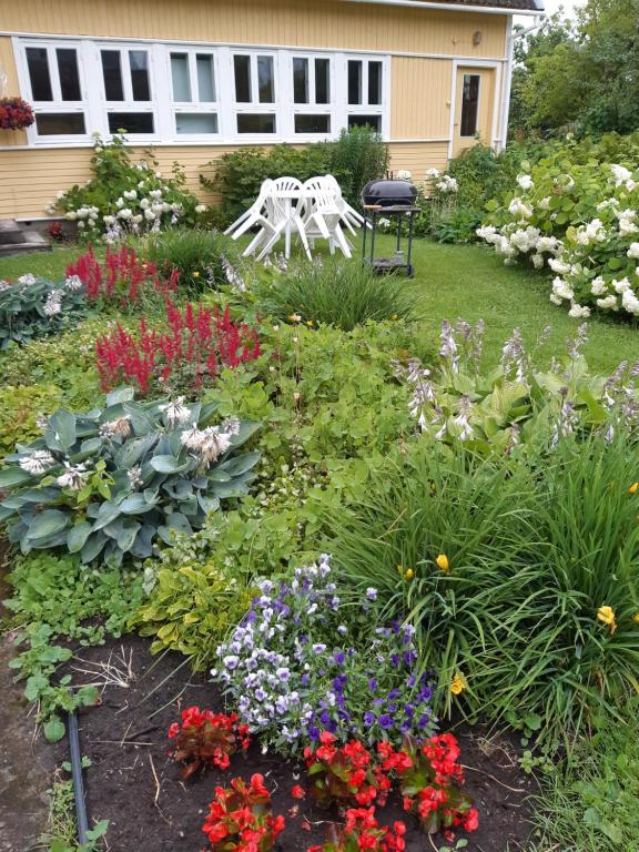 a garden with flowers and a chair in the yard at Aliise Garden Guesthause in Pärnu
