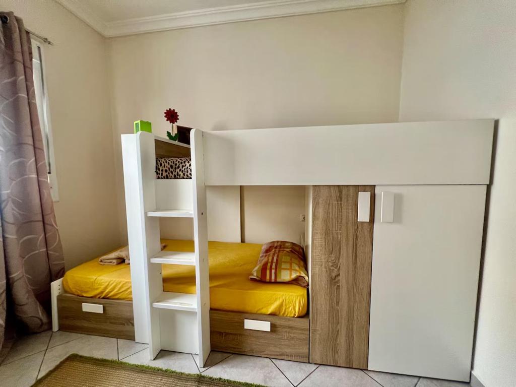 Etagenbett in einem Zimmer mit einem gelben Bett in der Unterkunft aslan appart in Martil