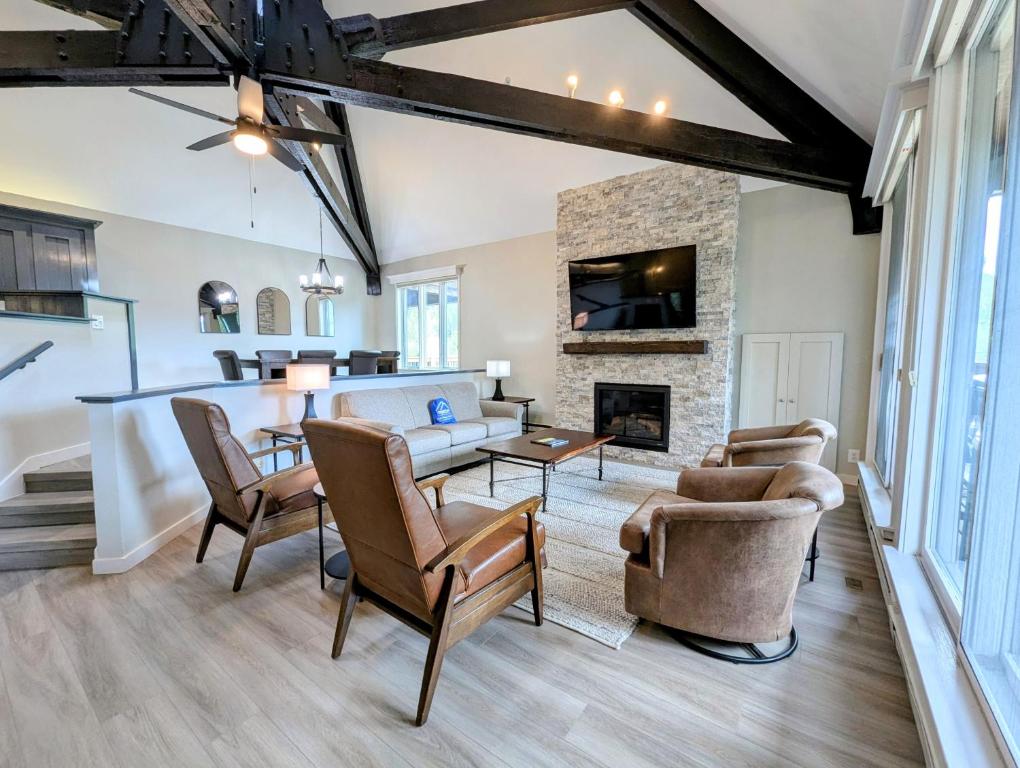 an open living room with a stone fireplace and a table at Soda Spring 1910 by SummitCove Lodging in Keystone