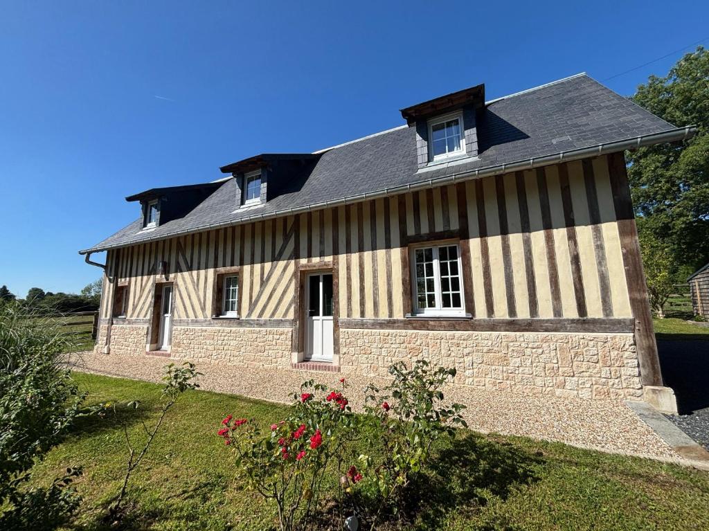 Saint-DésirにあるMaison normande à la campagneの黒と白の縞模様の古い家