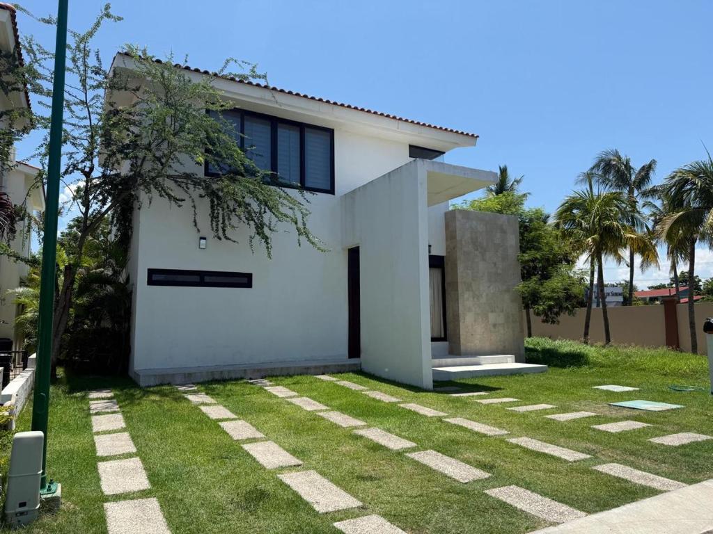 a white house with a grass yard at Beautiful home in El Tigre golf course Nuevo Vallarta! in Nuevo Vallarta 