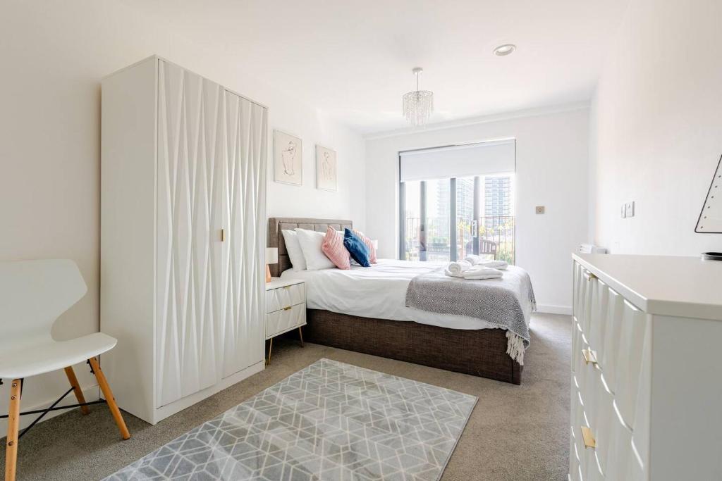 a white bedroom with a bed and a window at 2Bed 2Bath Private Balcony, Relaxing Waterfront View Apt, Parking FREE WiFi 10mins Media City, Salford Quays, Old Trafford, City Centre in Manchester