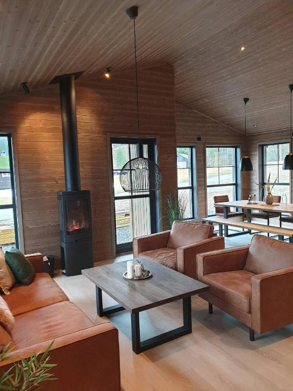 a living room with leather furniture and a fireplace at 2 cabins surrounded by beautiful nature in Stryn