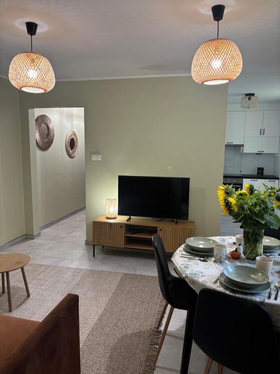 a living room with a table and a television at Apartament Grzmięca pl in Grzmięca