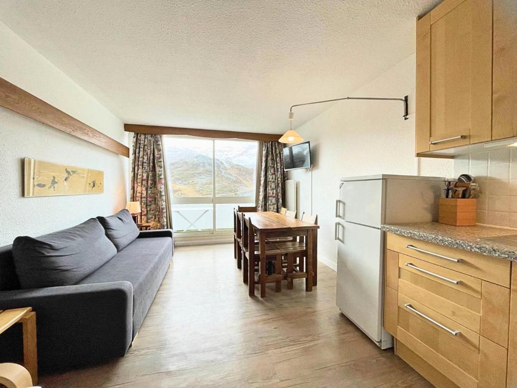 un salon avec un canapé et une cuisine avec une table dans l'établissement Résidence Nant Benoit - Appartement 8 personnes aux Ménuires avec vue sur la montagne MAE-4404, aux Menuires
