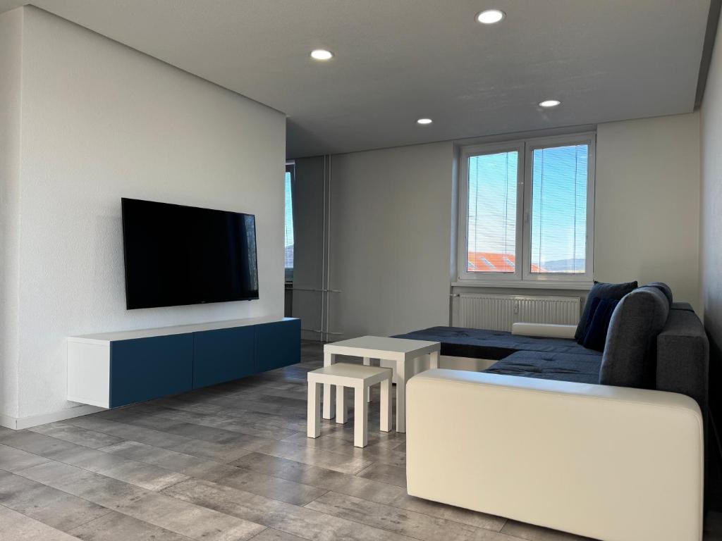 a living room with a couch and a tv on a wall at Urban apartment in Spišská Nová Ves