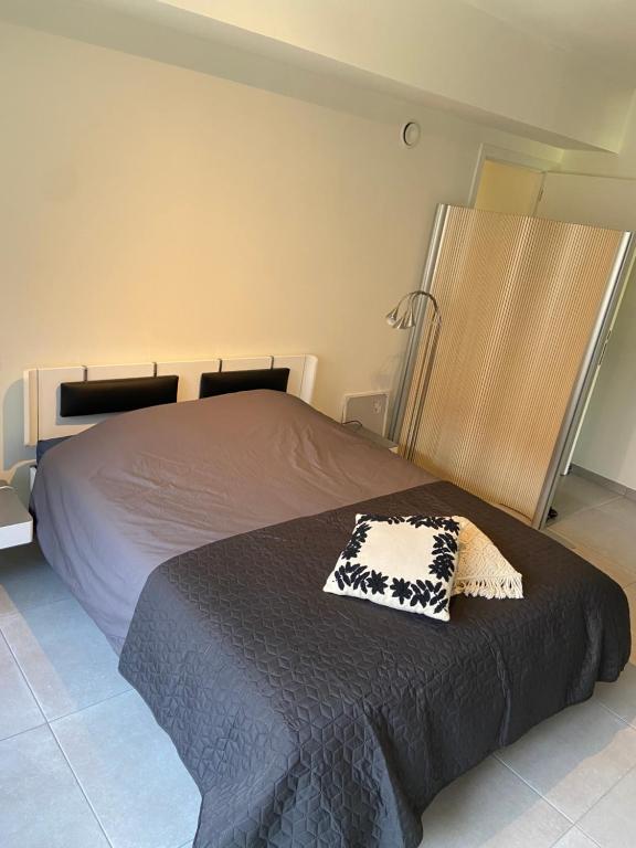a bedroom with a bed with a black and white blanket at Studio De Kevie in Tongeren
