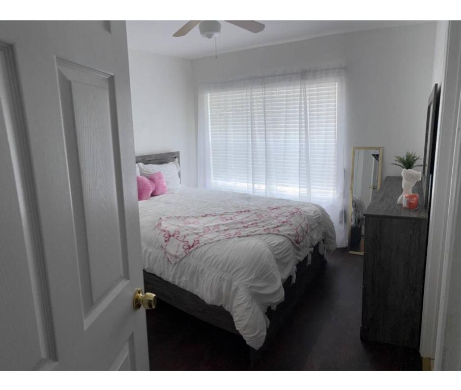 a bedroom with a bed with pink pillows and a window at Townhouse Retreat in Riverview