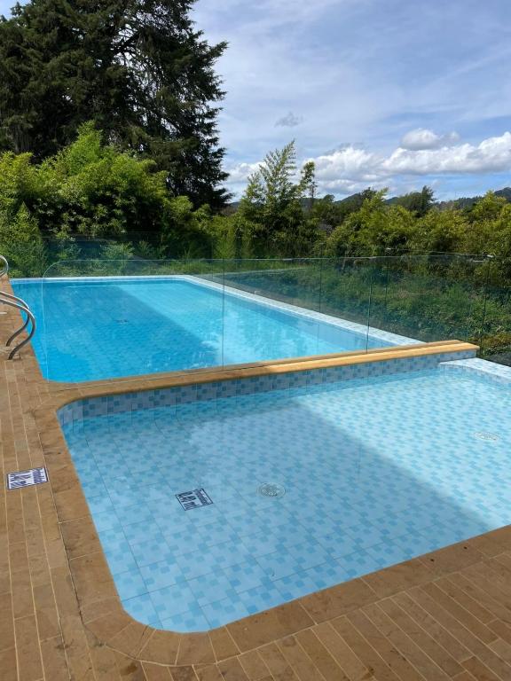 a large swimming pool with a fence around it at Suite Casa Grande in Rionegro