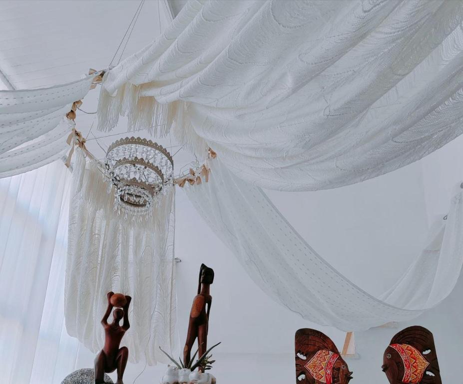 a room with white curtains and two figurines in it at Giardino Principi Dafagi in Capurso
