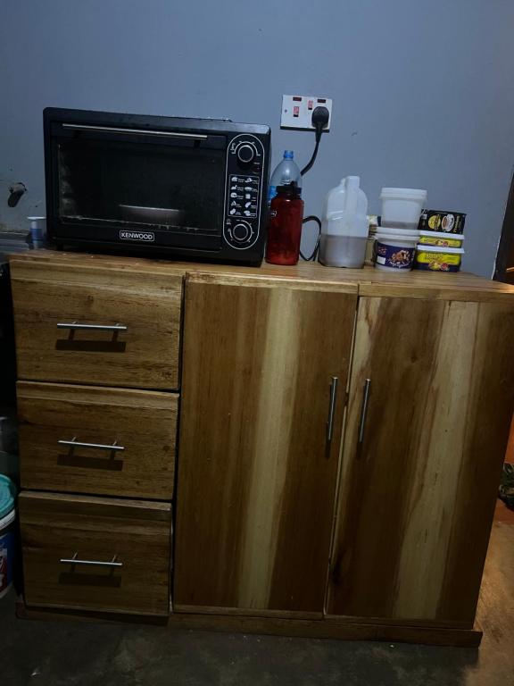 a microwave sitting on top of a wooden cabinet at Shambani Homestay in Moshi