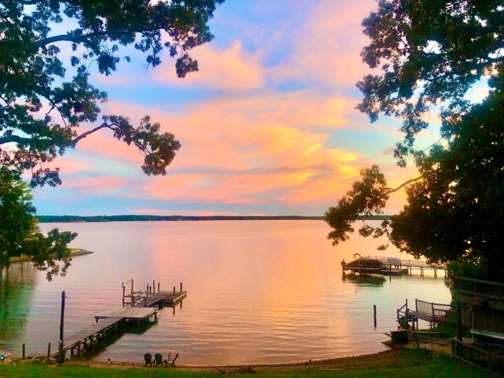 a view of a lake at sunset with a dock at Soul Beach Lake House in Chapin