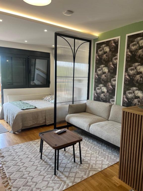 a living room with a couch and a bed at Studio Crnjanski in Jagodina