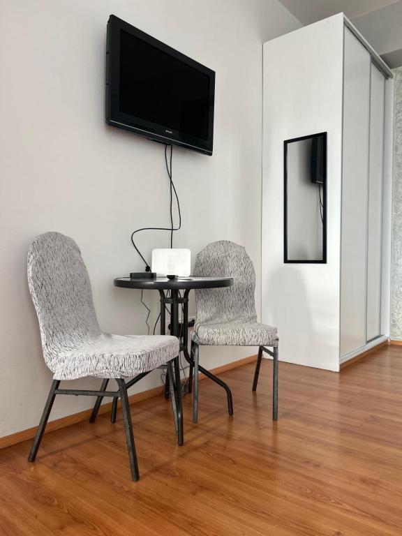 2 chaises et une table avec une télévision murale dans l'établissement 4 May Plaza, à Bratislava