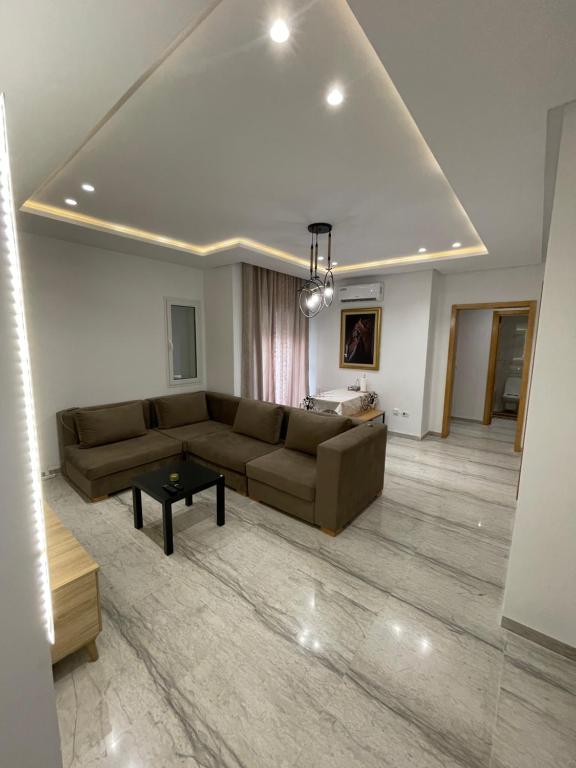 a living room with a couch and a table at Nid Douillet El Aouina, propre , calme et moderne, wifi, place parking in Tunis