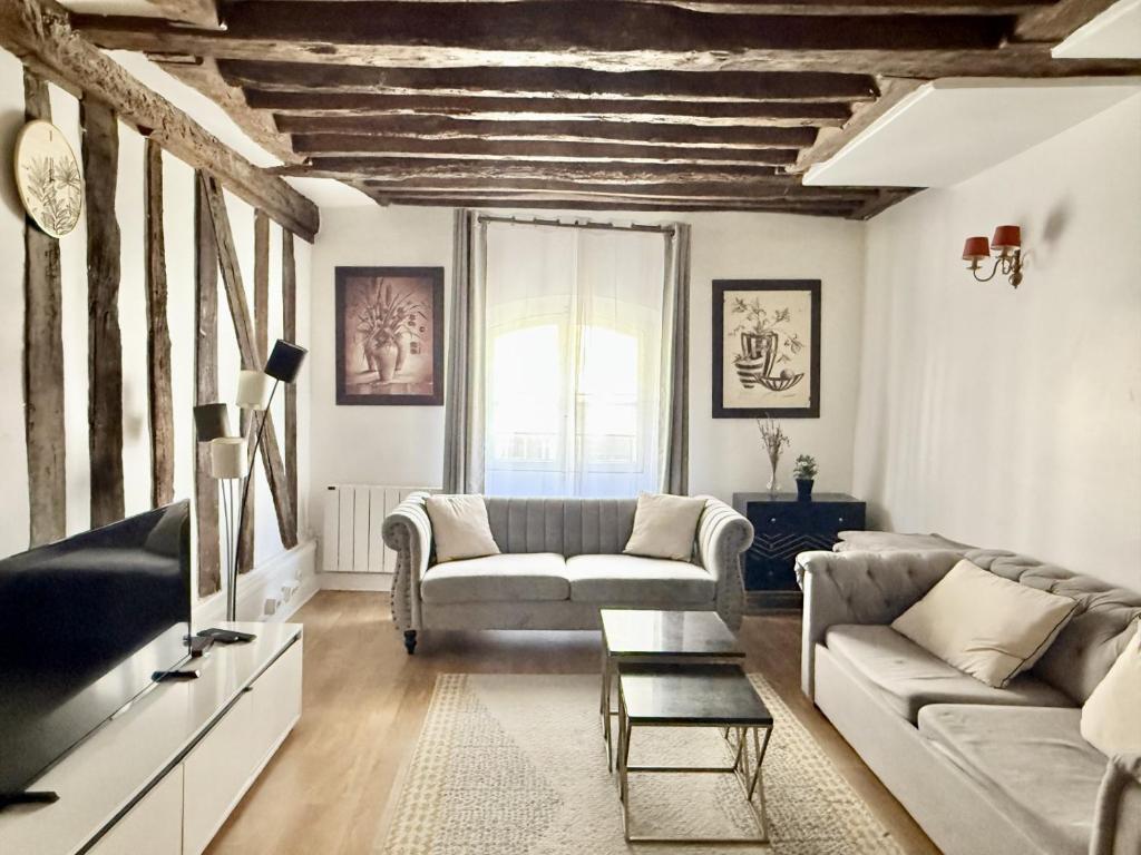 a living room with a couch and a table at 80 m2-Heart of Le Marais -Sleeps 6 in Paris