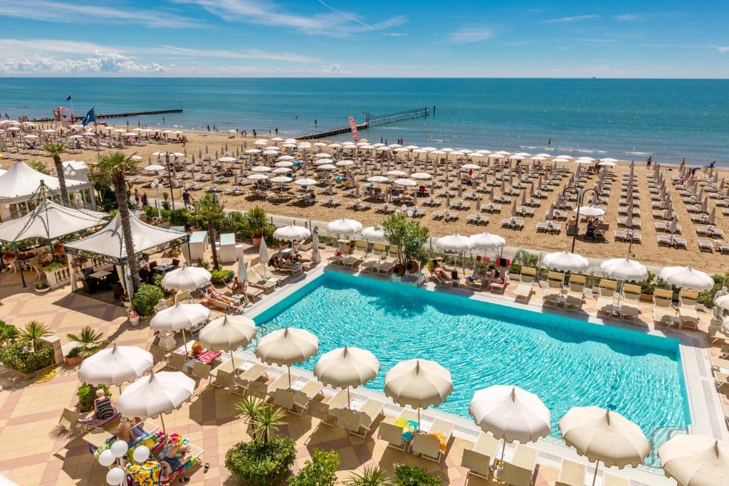 uma vista sobre uma praia com uma piscina e guarda-sóis em Luxor e Cairo The Beach Resort em Lido di Jesolo