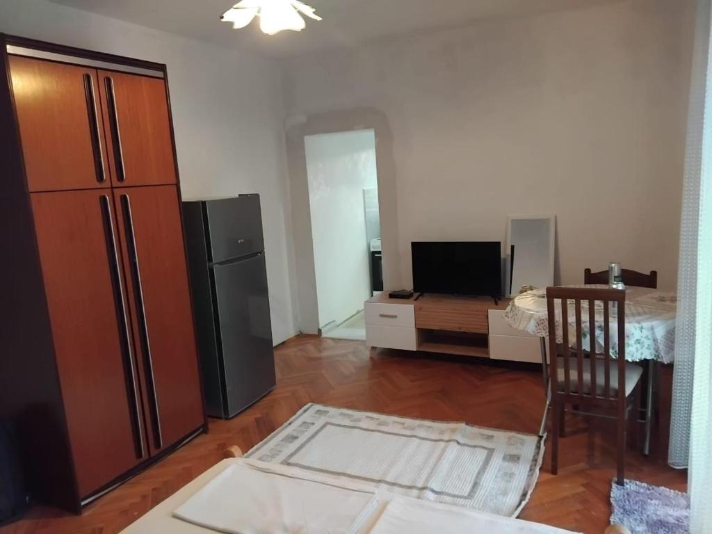 a living room with a refrigerator and a television at Apartments Maki 1 in Tivat