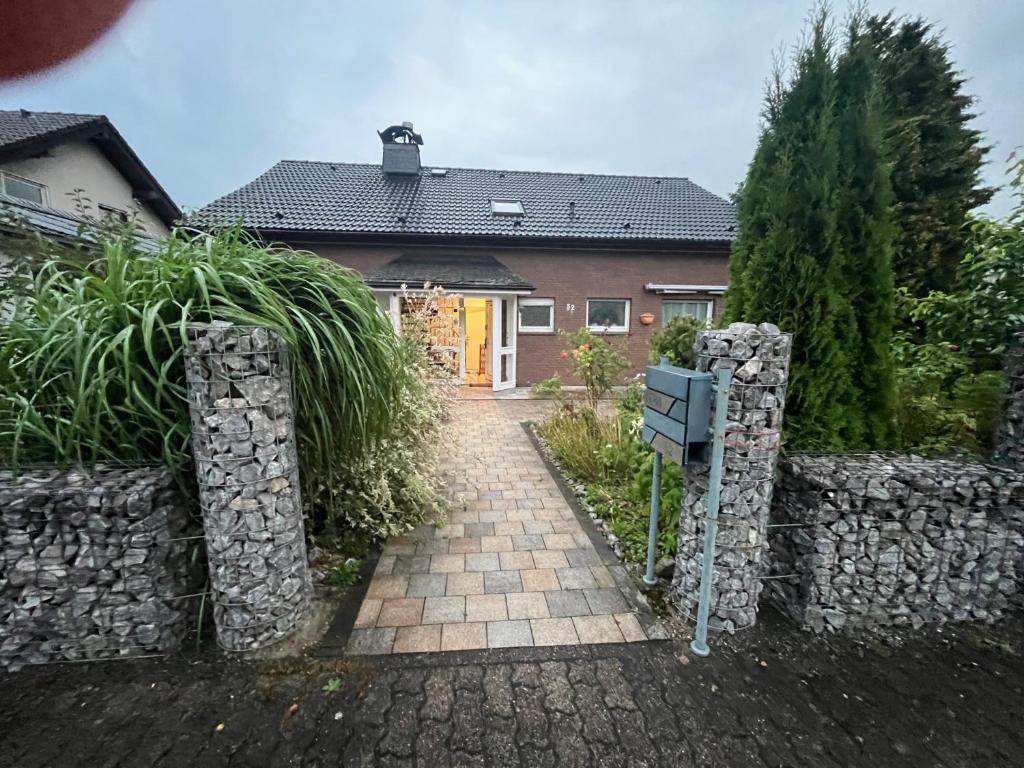 a house with a stone fence and a driveway at Unter den Wolken in Winterberg