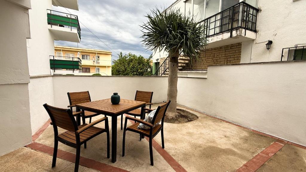 a table and chairs on a patio with a palm tree at 103 - Beachside Renovated 1BR apt w private garden in Cambrils