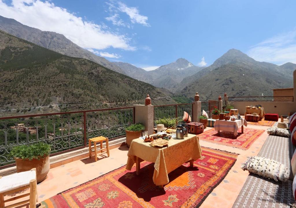 un balcon avec une table et une vue sur les montagnes dans l'établissement RiadAtlasChateau, à Imlil