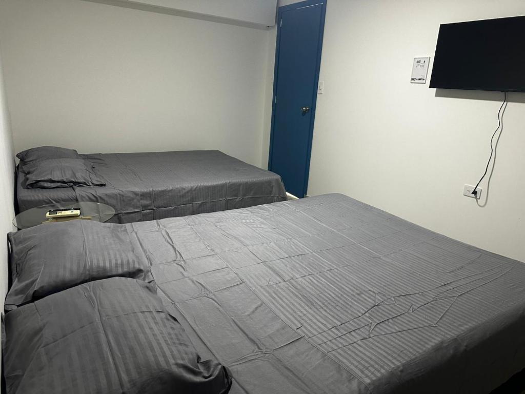 two twin beds in a room with a tv at Coliving habitacional in Cali
