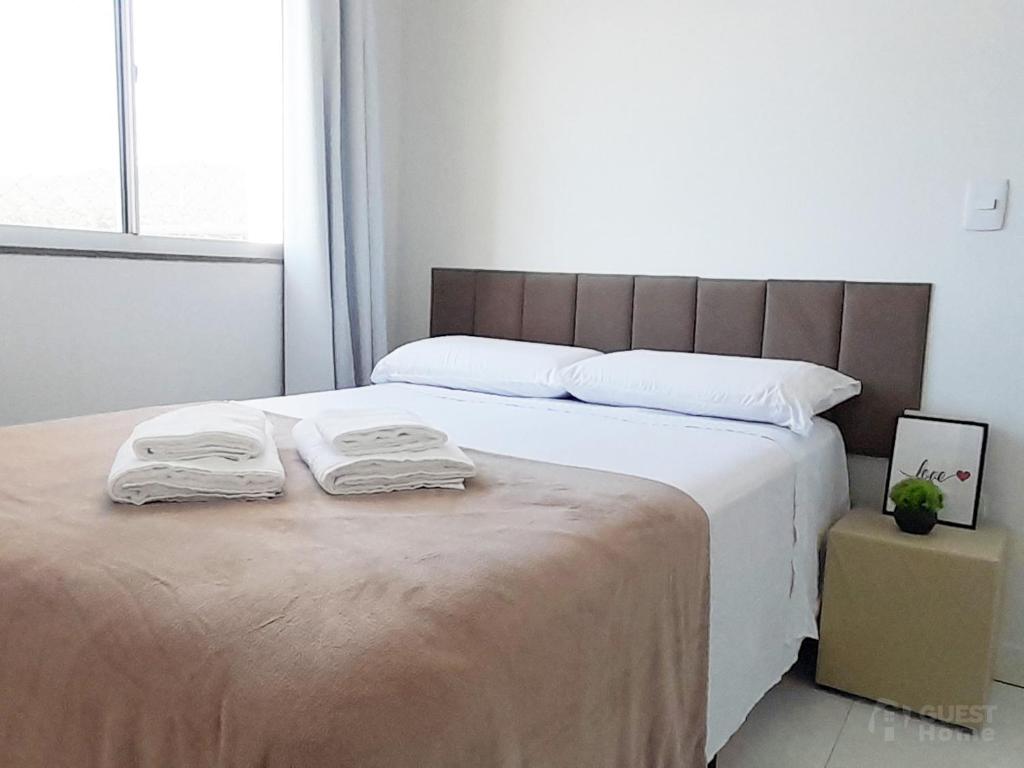 a bedroom with a bed with two towels on it at Apartamento em Condomínio - 2 Dormitórios in Camboriú