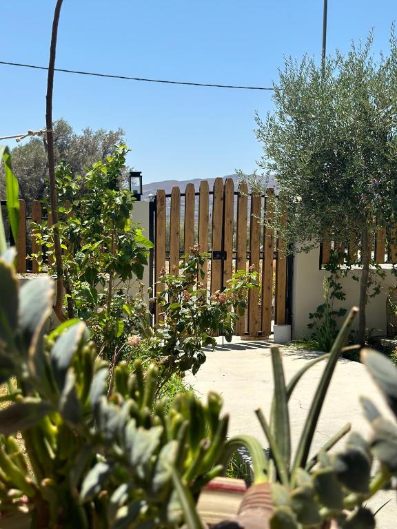 a wooden fence in a garden with trees at AlexandRos Home in Áyioi Dhéka