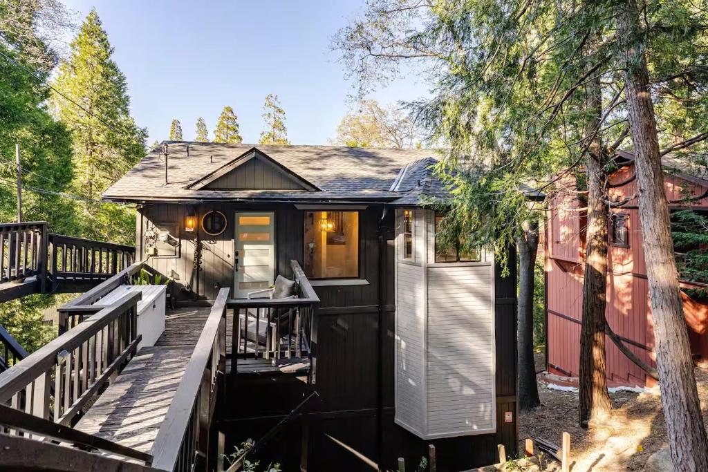 a black and white tiny house with a deck at Sleeps 10 Cozy Modern Cabin- 5 minutes to lake, fishing, & hiking in Crestline