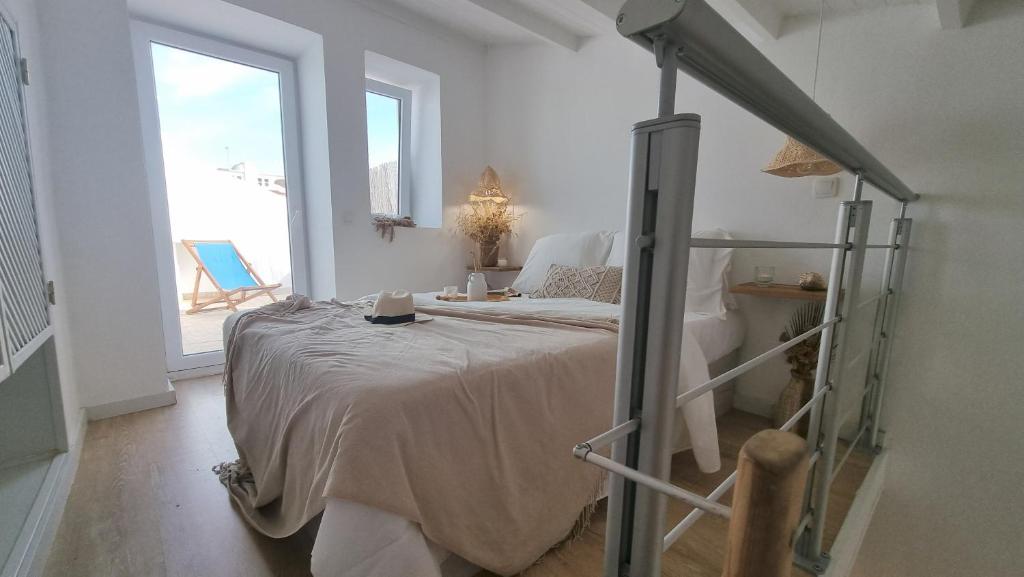 una camera bianca con un letto e una grande finestra di Casa Lagoa a Lagoa