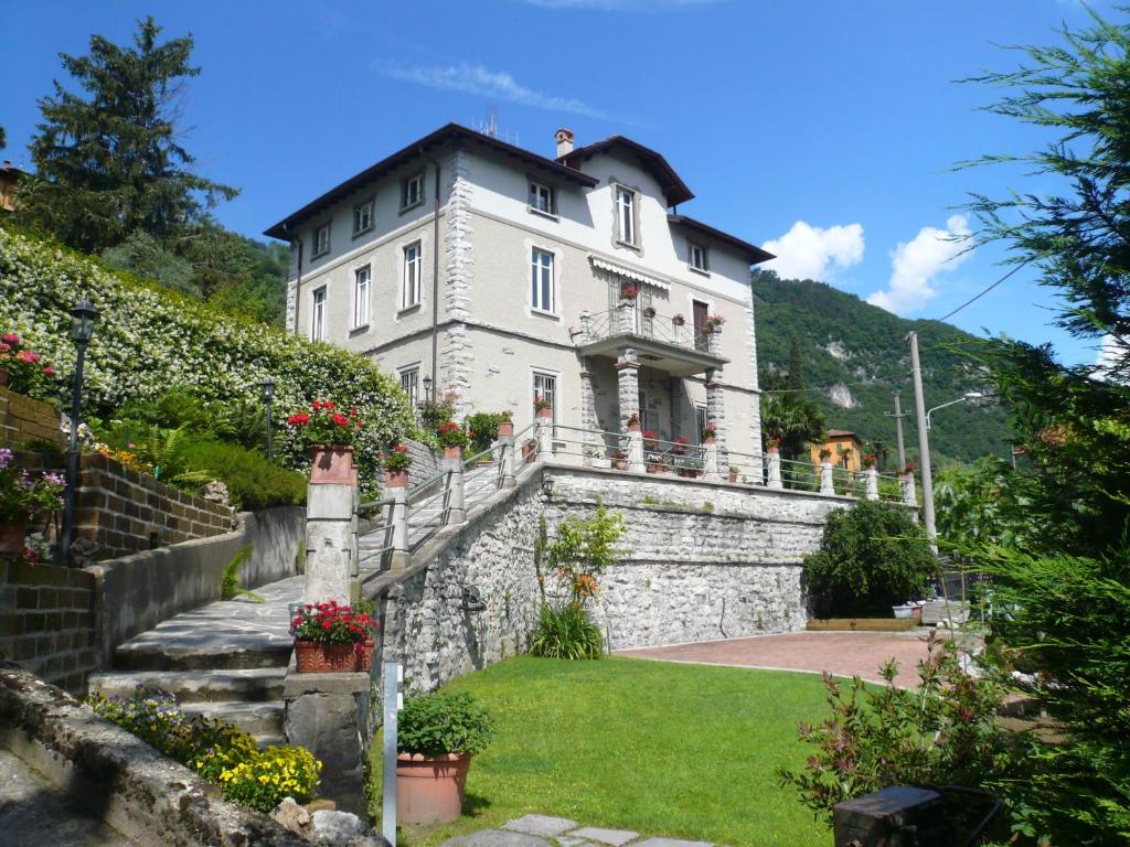 a large white house on a stone wall at Casa Beatrice in Oliveto Lario