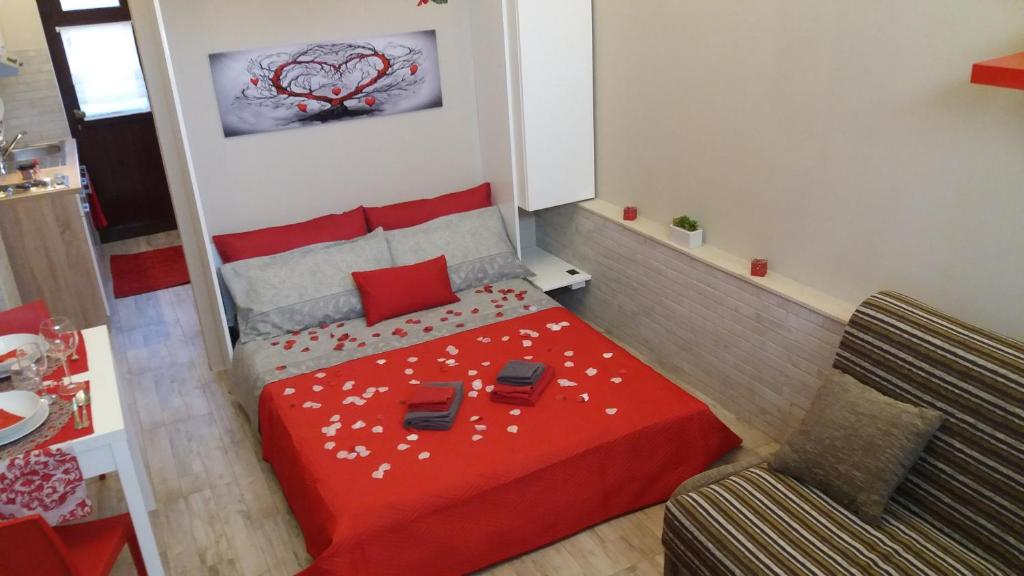 Piccola camera con letto rosso e divano. di Mishalay Apartment a Siracusa