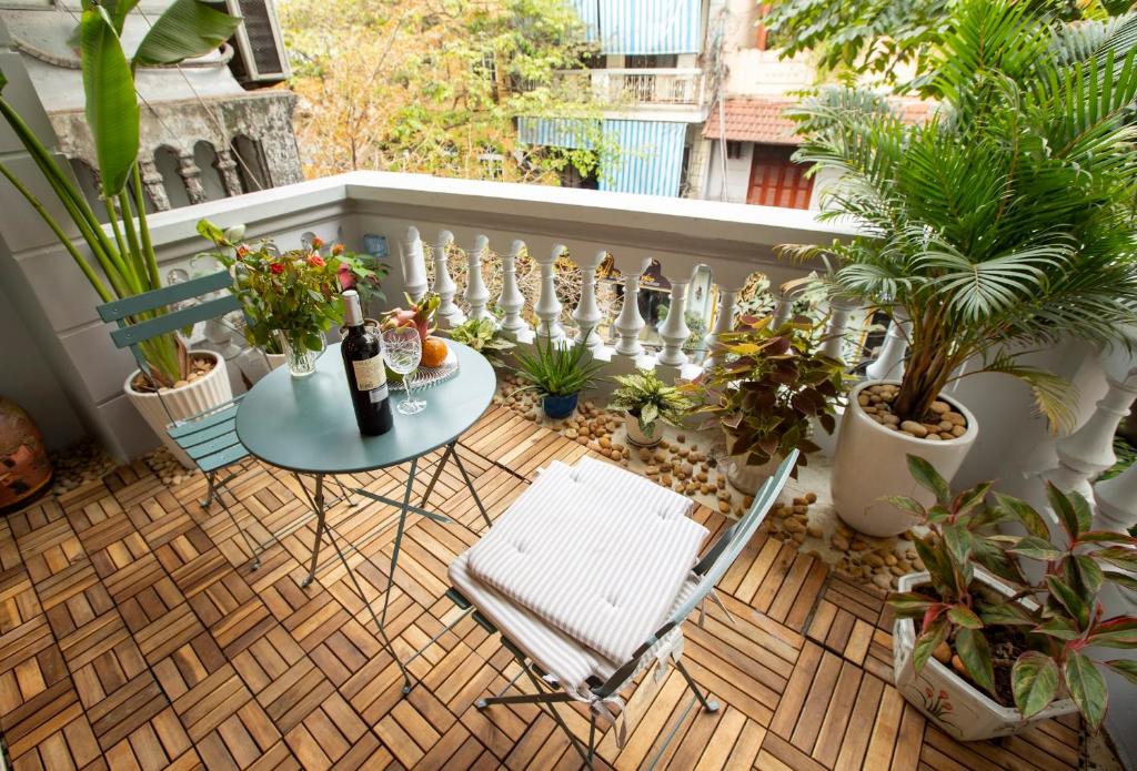 a balcony with a table and chairs and plants at Picturesque Hanoi Homestay in Hanoi