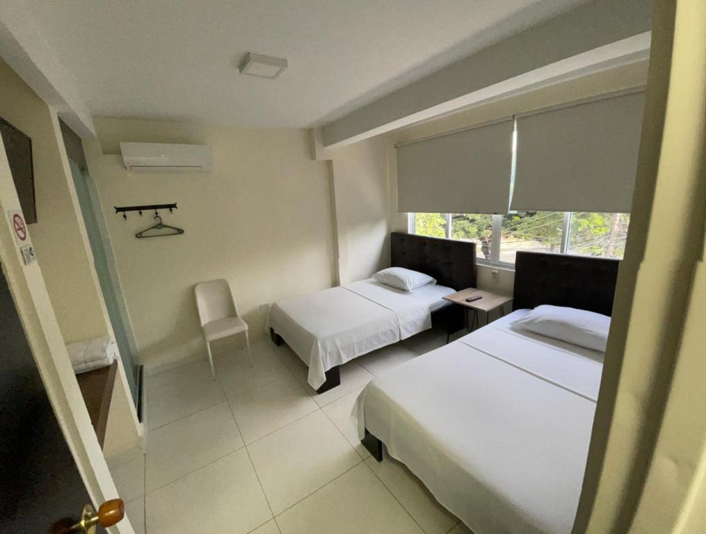 a hotel room with two beds and a window at Hotel Avei Suites in Cali