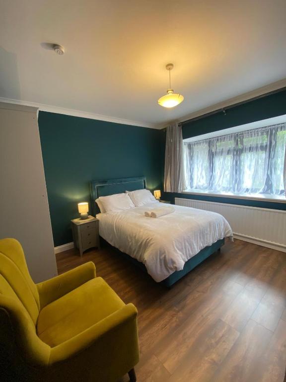 a bedroom with a bed and a chair and a window at Two double bedroom self contained Retreat in Thundersley