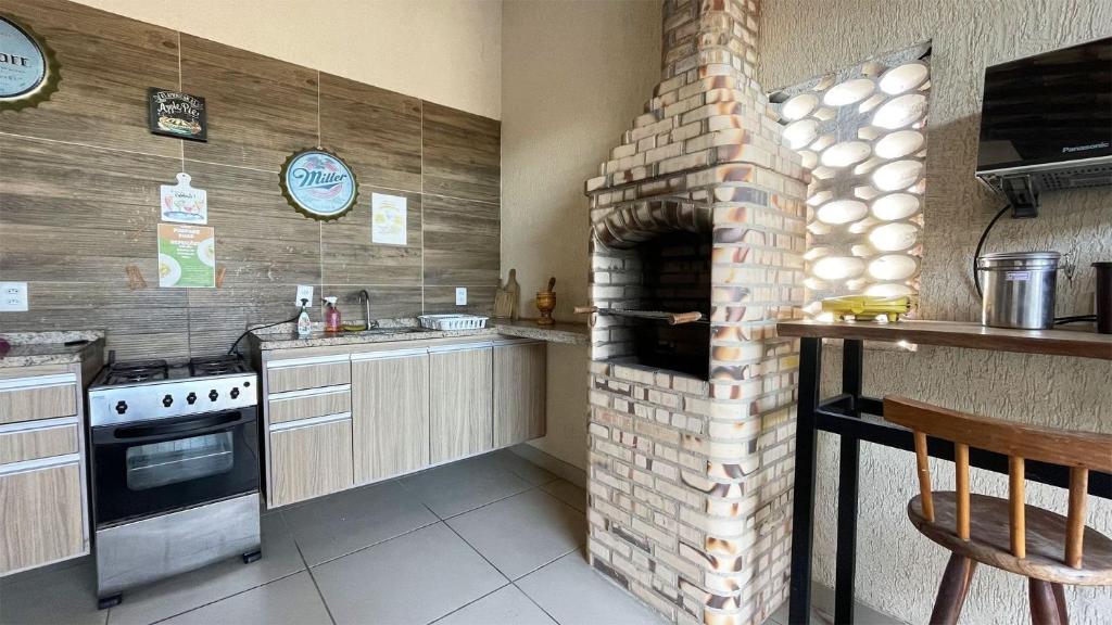 eine Küche mit einem Steinofen in der Ecke in der Unterkunft The Férias | Suites Praia in Cabo Frio