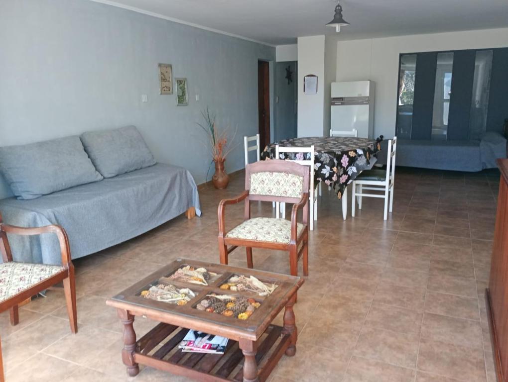 a living room with a couch and chairs and a table at Alojamiento Temporario El Nogal in Tandil