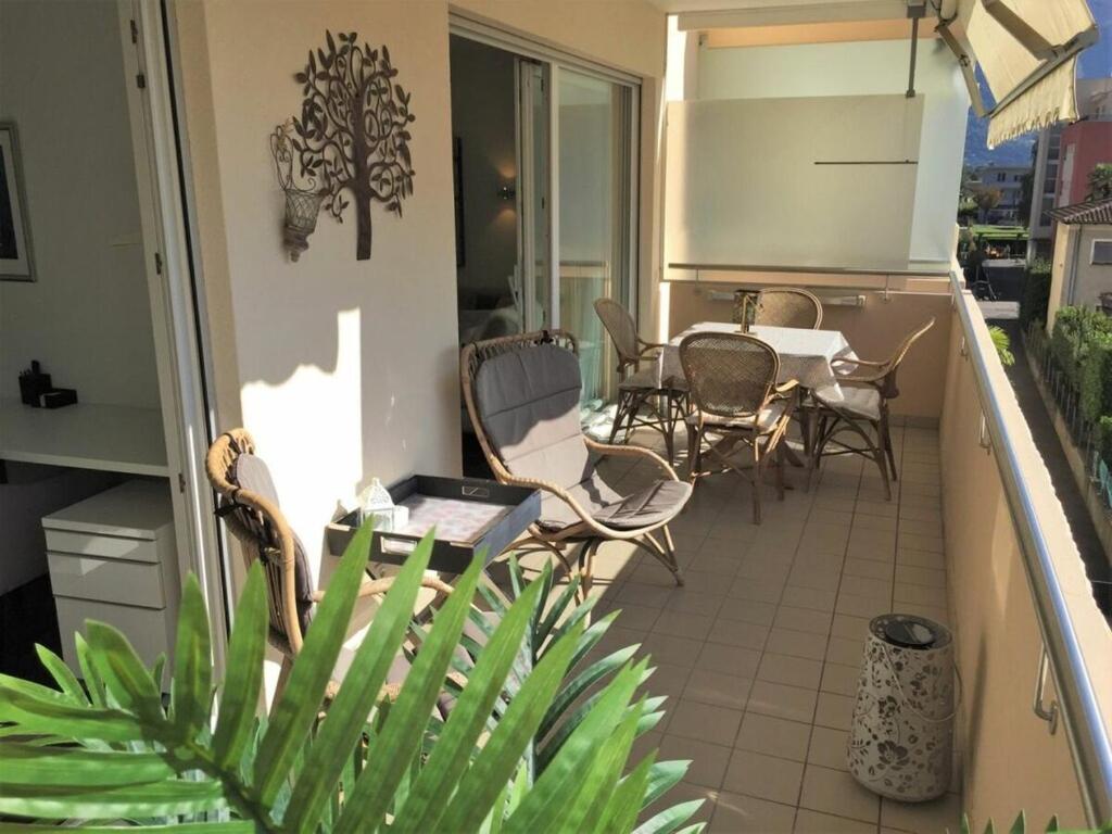 Un balcón de una casa con una mesa y sillas. en 1-bedroom apartment, en Ascona
