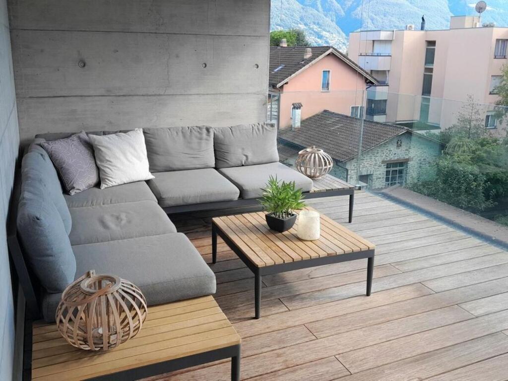 a living room with a couch and tables on a balcony at 1-bedroom holiday apartment in Ascona